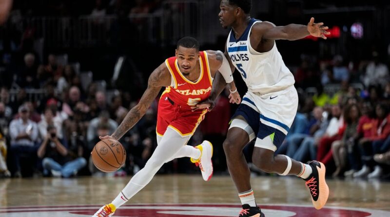 Atlanta Hawks guard Dejounte Murray (5) drives against Minnesota Timberwolves guard Anthony Edwards (5) during the first half of an NBA basketball game,